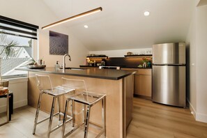 A modern kitchen with a central island, stainless steel appliances, and a view of the outside. - NEW Cozy Carriage House in Congress Park - Denver (Denver)