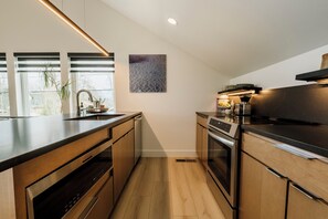 A modern kitchen with a built-in oven, a dishwasher, and a stove. - NEW Cozy Carriage House in Congress Park - Denver (Denver)