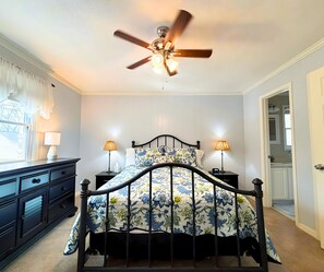 A bedroom with a bed, bedside lamps, a ceiling fan, and a dresser. - Stunning view of the North Golf Course from the back deck. (Cherokee Village)