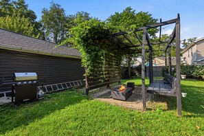 A backyard with a grill, a fire pit, and a swing set. - Heart of Ohio City, Sleeps 8 & Fenced Yard (Cleveland)