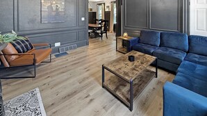 Een moderne woonkamer met een bank, een salontafel en een fauteuil.