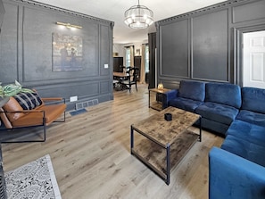 Ein modernes Wohnzimmer mit einer Couch, einem Couchtisch und einem Sessel.