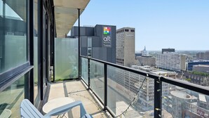 Un balcon offrant une vue sur le paysage urbain, avec notamment une enseigne d’hôtel et un bâtiment Radisson.