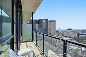 Ein Balkon mit Blick auf eine Stadtlandschaft, einschließlich eines Hotelschildes und eines Radisson-Gebäudes.