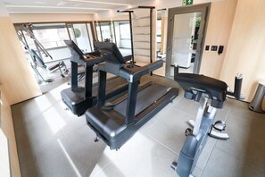 A gym with treadmills, a stationary bike, and weight machines. - Lindo apto ao lado do Aerop de Congonhas (São Paulo)