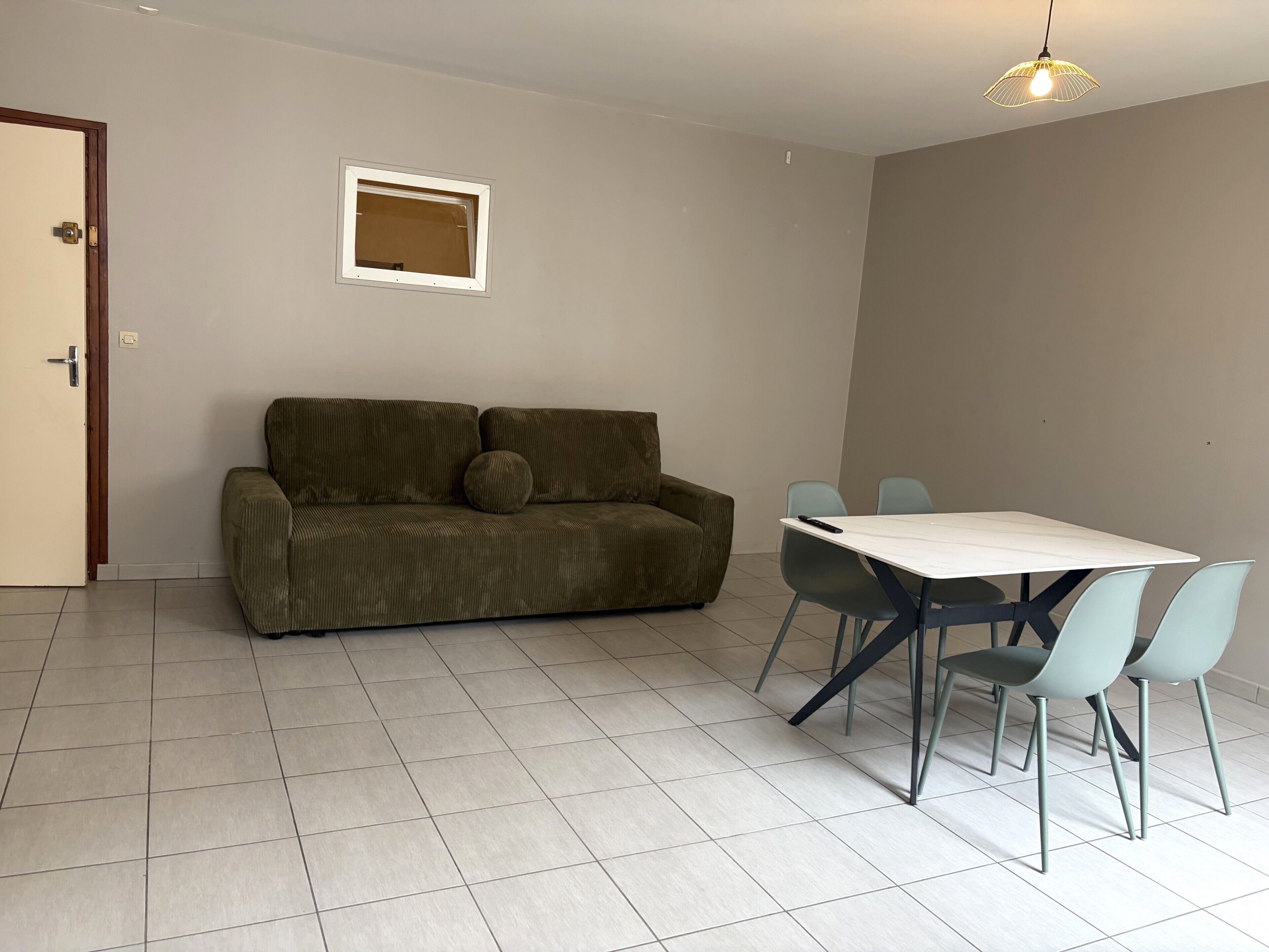 A living room with a sofa, a small table, and two chairs.