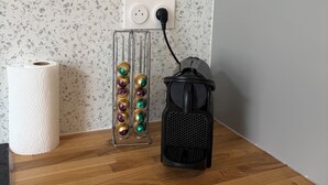 A wooden table with a paper towel roll, a metal container with colorful objects, and a black lantern plugged into a wall socket. - Apartment in Downtown Montluel (Montluel)