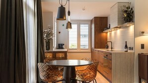 A modern kitchen with a central island, wooden cabinets, and a built-in oven. - 11 Earl by MajorDomo | Modern 2-Bedroom Apartment in the Heart of Downtown Queenstown, Steps to Lake, Dining & Shops (Queenstown)
