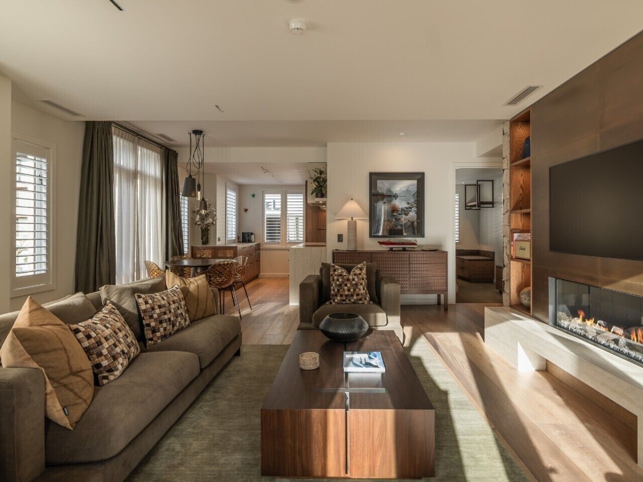 Un salon moderne avec un canapé, une table basse et une cheminée.