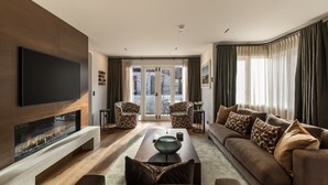A modern living room with a fireplace, a flat-screen TV, a sofa, and two armchairs. - 11 Earl by MajorDomo | Modern 2-Bedroom Apartment in the Heart of Downtown Queenstown, Steps to Lake, Dining & Shops (Queenstown)