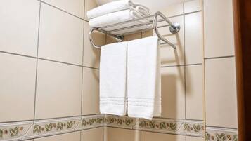 Un baño con un perchero que sostiene dos toallas dobladas.