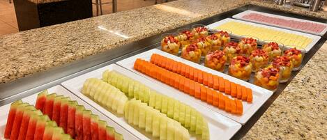 Un bufé con diversas opciones de fruta y postres.