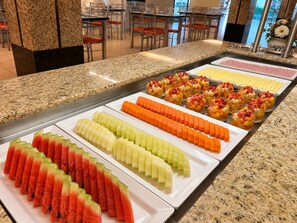 A buffet with various fruit and dessert options.