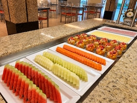 Un bufé con diversas opciones de fruta y postres.