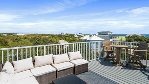 A deck with outdoor furniture, a view of the ocean, and a distant building. - Blue Mountain View | Private Pool, Rooftop Deck & Bikes (Santa Rosa Beach)
