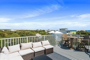 A deck with outdoor furniture, a view of the ocean, and a distant building. - Blue Mountain View | Private Pool, Rooftop Deck & Bikes (Santa Rosa Beach)