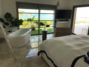 A bedroom with a large bed, a bathtub, and a view of the ocean. - THE CROWN JEWEL: The largest, private property with direct beach access (ISLA MUJERES SONA PENINSULAR)