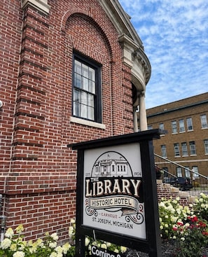 A brick building with a sign for 'The Library Historic Hotel' in St. Joseph, Michigan.