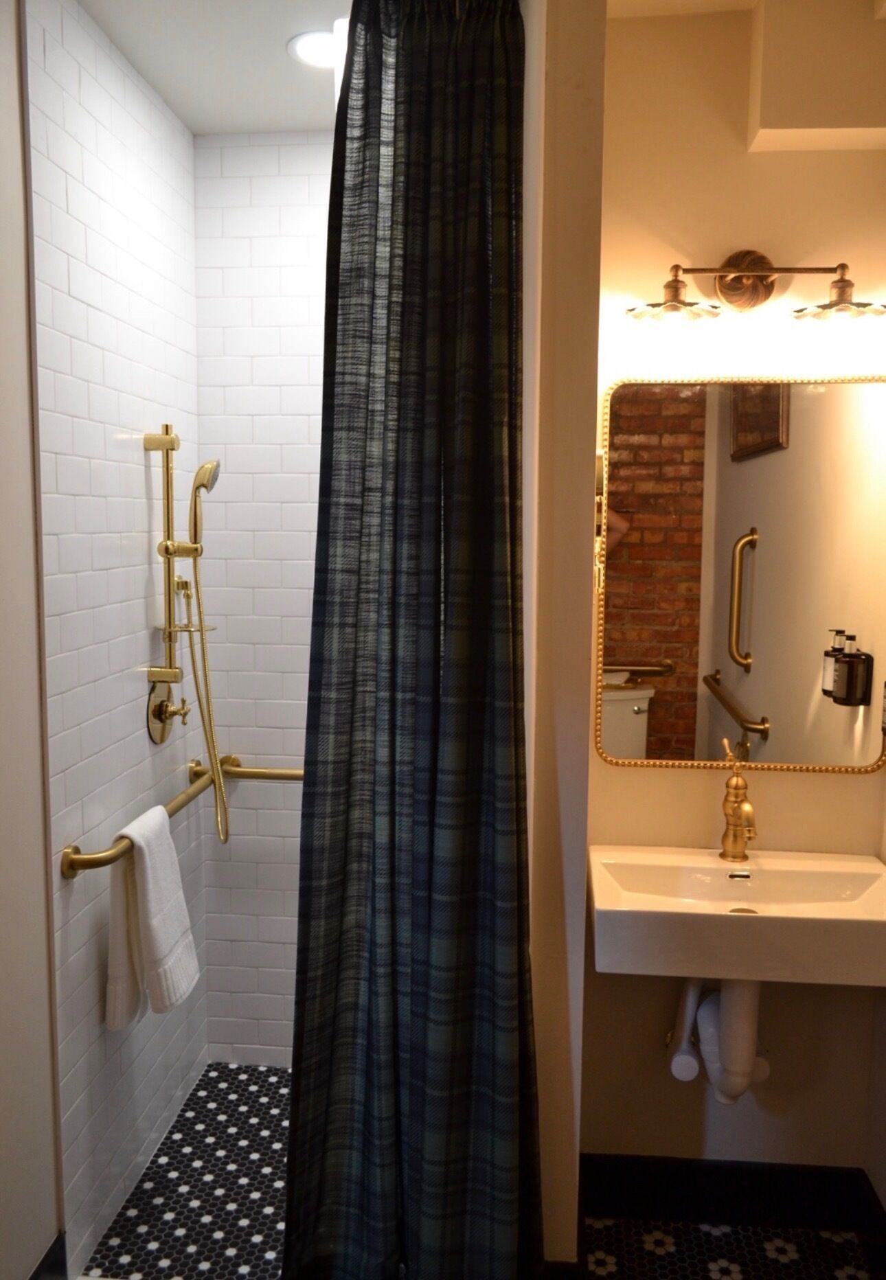 A bathroom with a shower, a sink, and a mirror.