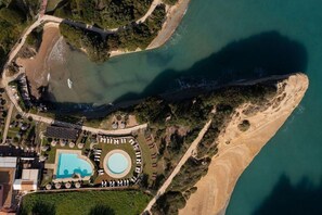 An aerial view of a coastal property with a swimming pool, a beach, and a bridge. - Canal D Amour Apartments (Corfu)