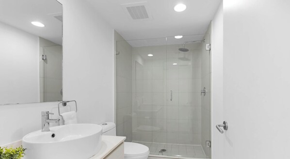 A modern bathroom with a large white sink, toilet, and glass-enclosed shower. - New! 3 BDR Condo Pool Gym - Private Balcony (Hallandale Beach)