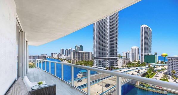 A balcony with a view of a city skyline, a body of water, and a bridge. - New! 3 BDR Condo Pool Gym - Private Balcony (Hallandale Beach)