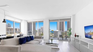 A modern living room with a sofa, coffee table, and a TV. - New! 3 BDR Condo Pool Gym - Private Balcony (Hallandale Beach)