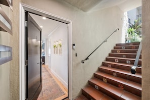 A staircase with a handrail and patterned tiles, leading to an upper floor. - Penthouse Views without the lower floors (Oakland)