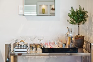 En bardisk med en spegel, en krukväxt och olika typer av barutrustning och glas.