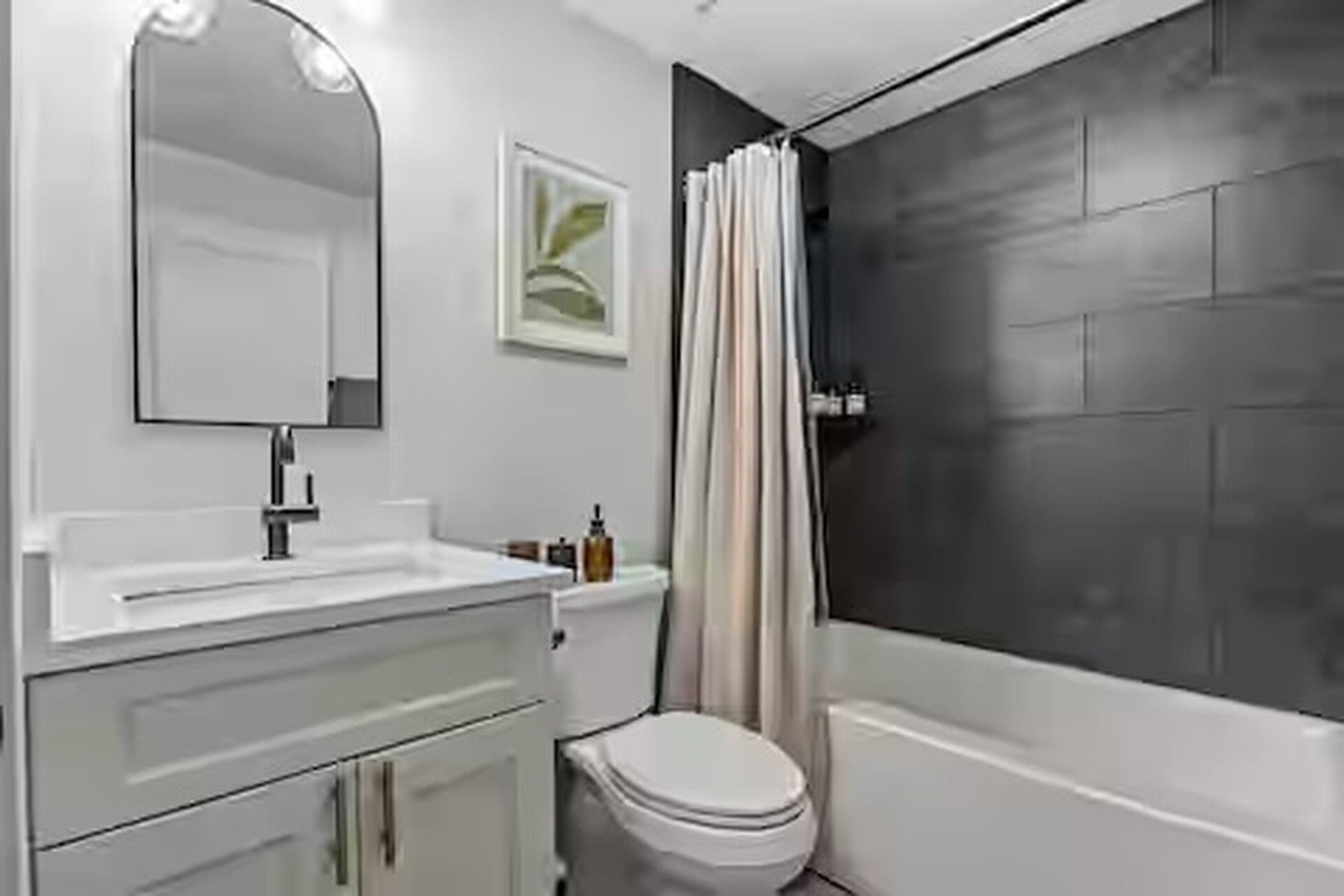 Un bagno moderno con un lavandino bianco, un WC e una vasca da bagno.