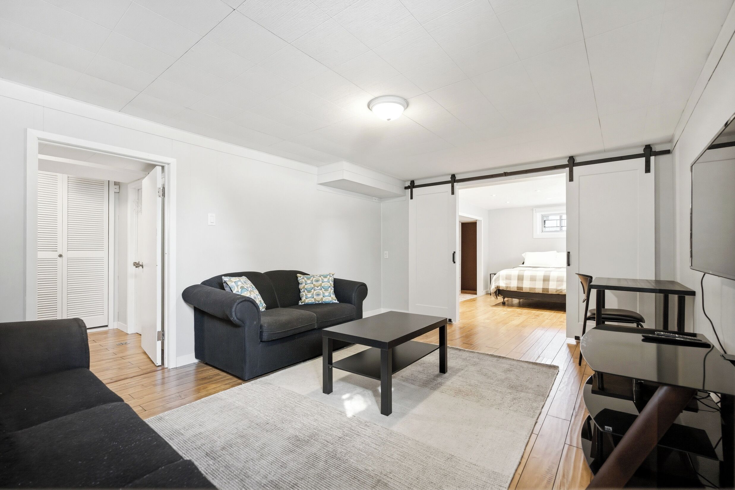 Ein modernes Wohnzimmer mit Sofa, Couchtisch und TV-Möbel.