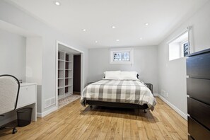 Una camera da letto con un letto, una scrivania, un armadio e un guardaroba a muro.