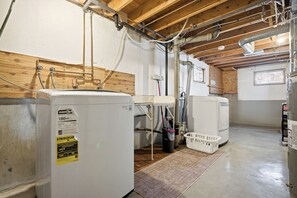 Een wasserette met een wasmachine, droger en boiler.