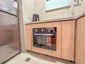 A kitchen with a built-in oven and a refrigerator. - Copacabana: renovated, 3 minutes from the beach (Rio de Janeiro)