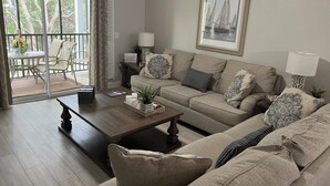 Una sala acogedora con sofá, mesa de centro y comedor con sillas y mesa.