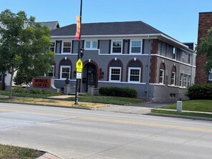 A two-story building with a sign for 'Monroe Lofts' and a pedestrian crossing sign.