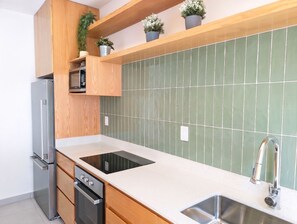 A modern kitchen with a built-in oven, dishwasher, and a stainless steel sink. - Modern Coastal Oasis with Private Pool (Puerto Morelos)