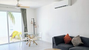 Ein modernes Wohnzimmer mit einer Couch, einem runden Couchtisch und einem Deckenventilator.