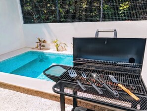 A poolside area with a grill and barbecue utensils. - Modern Coastal Oasis with Private Pool (Puerto Morelos)