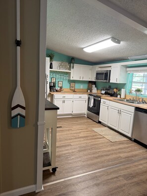 A kitchen with white cabinets, a microwave, and a dishwasher. - Cozy lookout nook your next perfect vacationescape (Eufaula)