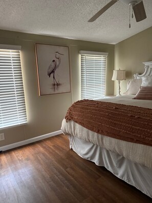 A bedroom with a large bed, a ceiling fan, and two windows with blinds. - Cozy lookout nook your next perfect vacationescape (Eufaula)