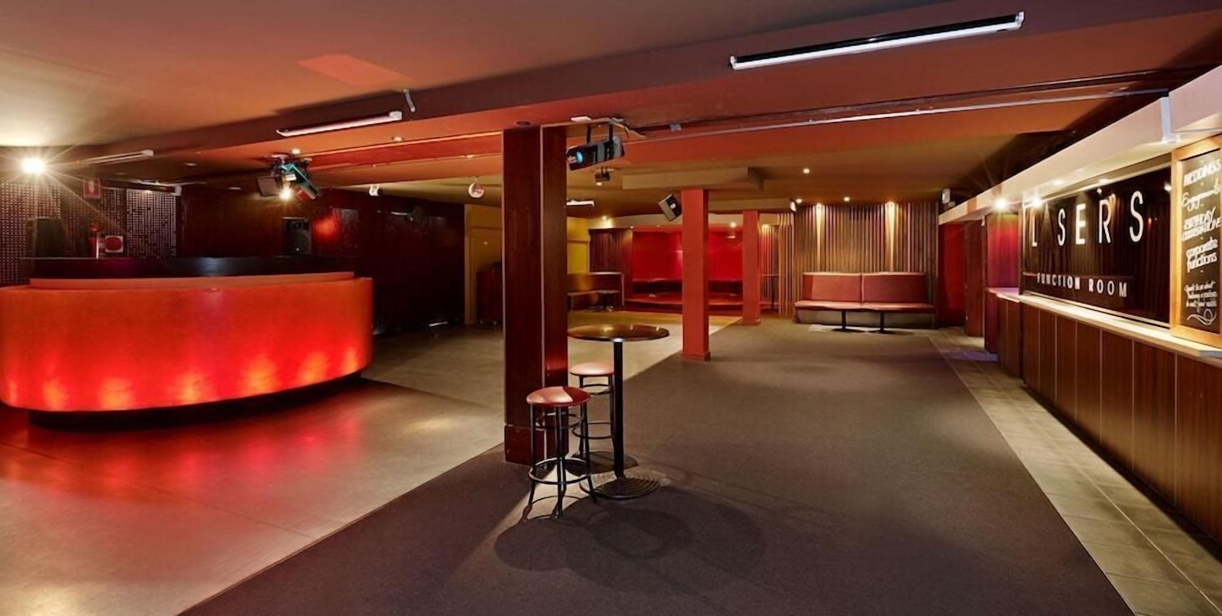 A hotel lobby with a reception desk, seating area, and a wall with a sign.