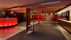 A hotel lobby with a reception desk, seating area, and a wall with a sign. - Waltzing Matilda Hotel (Melbourne)