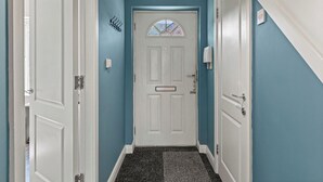A hallway with a white door, a mailbox, and a coat rack. - Cozy 4-Bed Birkenhead Home, Ideal for Contractors (Merseyside)