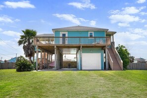 A two-story house with a covered porch and a garage. - Private Paradise w/Hot Tub @ The SeaBird (Galveston)