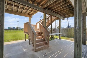 Eine Holztreppe führt zu einem überdachten Außenbereich mit Betonboden.