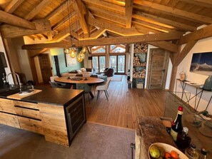 A spacious kitchen with a wooden island, dining area, and a view of the outdoors. - 3rd floor, terrace, fireplace or stove, tv, 157m², Peisey-Vallandry (Peisey-Nancroix)