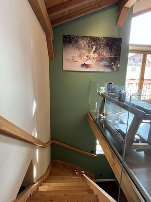 A wooden staircase leading to a glass railing with a view of a snowy landscape painting above. - 3rd floor, terrace, fireplace or stove, tv, 157m², Peisey-Vallandry (Peisey-Nancroix)