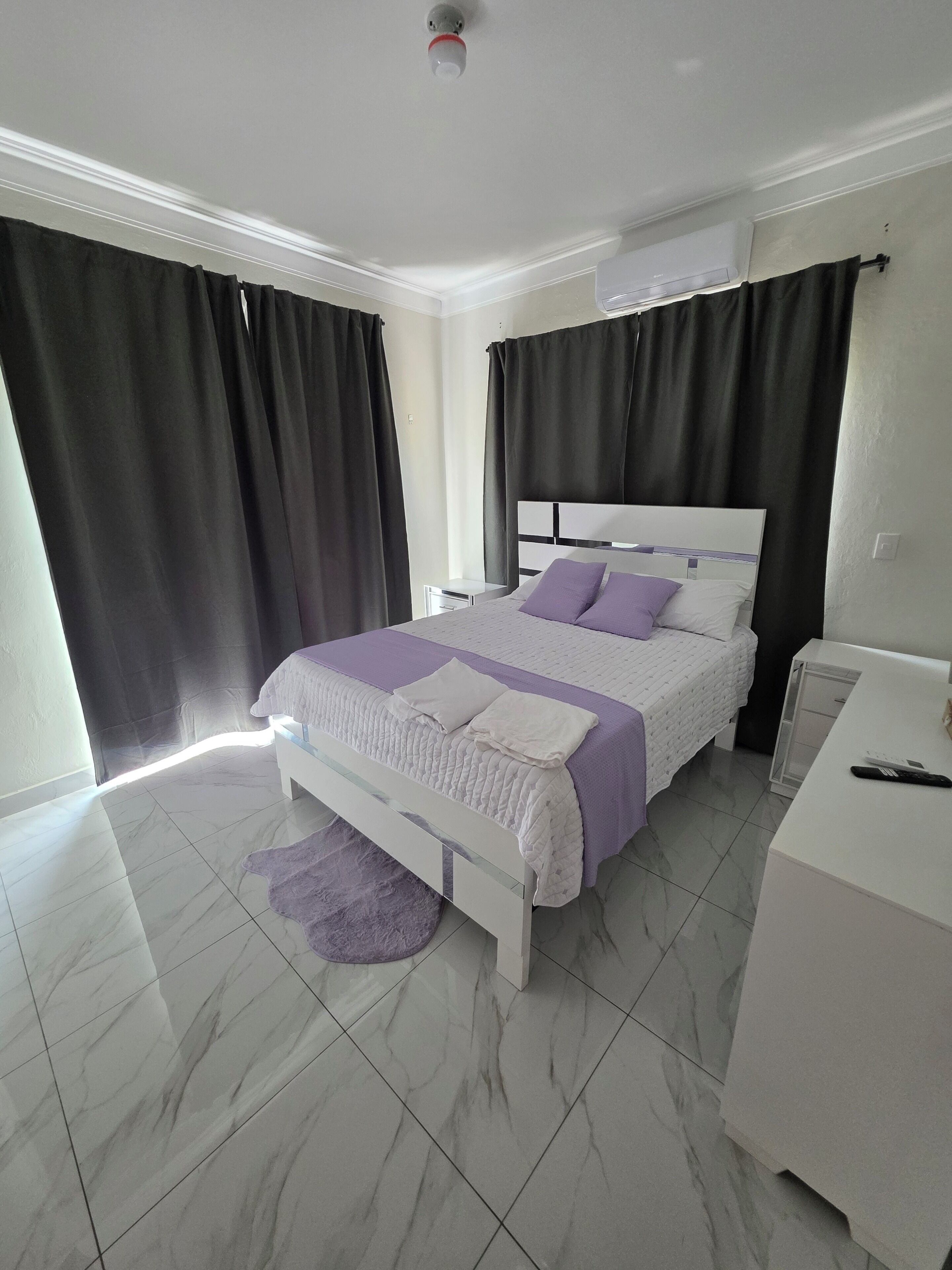 Un dormitorio con una cama, una mesita de noche y un escritorio con una silla.