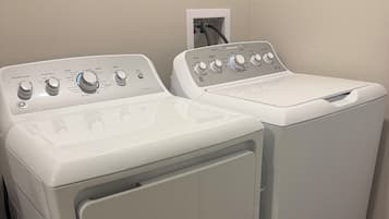 Two front-loading washing machines in a laundry room with a wooden floor.
